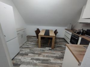 una piccola cucina con tavolo e sedie in legno di Nah an Mercedes-Werke a Stoccarda