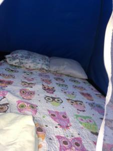 a bed with a blanket and pillows on it at Camping beira mar in Bertioga