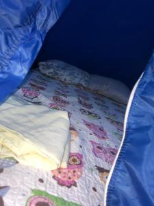 a bed with a quilt and pillows on it at Camping beira mar in Bertioga