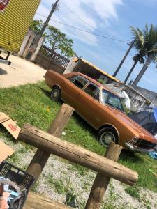 a car parked on the grass next to a fence at Camping beira mar in Bertioga