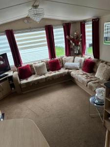 a living room with a long couch with red pillows at BRENDA in Meliden