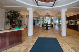 a lobby with columns and a blue rug on the floor at Kauai Beach Resort Room 2309 in Lihue