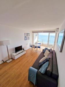 sala de estar con sofá y mesa con TV en Casa dos Cotas - Amazing Seaside Apartment with Balcony, en Cascais