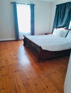 1 dormitorio con 1 cama y suelo de madera en Top House on Lynnfield, en Lynnfield Park