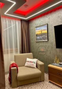 un soggiorno con sedia e TV di Deluxe Apartment 33 Mountain Lodge Pamporovo a Pamporovo