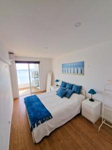 a bedroom with a large bed with blue pillows at Casa dos Cotas - Amazing Seaside Apartment with Balcony in Cascais