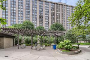 a pergola with chairs and tables in front of a building at Quiet Efficiency Condo - Downtown Minneapolis in Minneapolis
