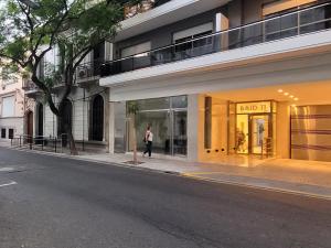 a woman walking down a street in front of a building at Saint Louis Aparts in Rosario