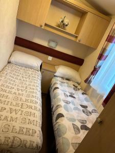 two beds in a small room with a window at BRENDA in Meliden