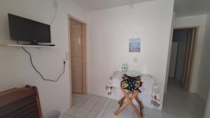 Habitación con mesa y TV en la pared. en Residencial Henrique, en Florianópolis