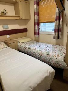 a small bedroom with two beds and a window at BRENDA in Meliden