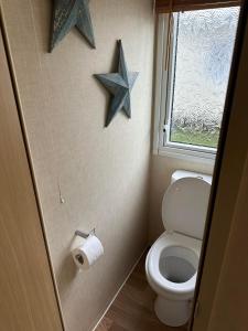 a bathroom with a toilet and two stars on the wall at BRENDA in Meliden
