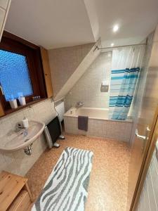 a bathroom with a sink and a bath tub and a sink at Ferienwohnung im Herzen Tribergs in Triberg