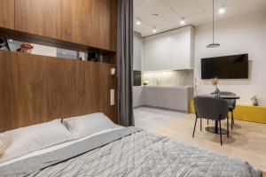 a bedroom with a bed and a desk and a kitchen at Old City Apartments in Lviv +285 photos