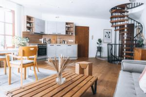 uma sala de estar com uma mesa de madeira e uma cozinha em Loftwohnung am Park em Regensburg