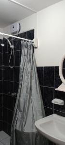 a bathroom with a shower curtain and a sink at Travelershouse Casa Hospedaje in Huanchaco