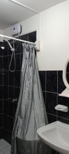 a bathroom with a shower curtain and a sink at Travelers' House Casa Hospedaje in Huanchaco