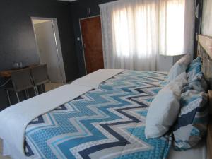 - une chambre avec un lit doté d'une couette dans l'établissement POVI Holiday Home, à Kasane