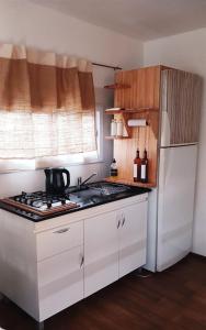 a kitchen with a stove and a white refrigerator at BlackHouse in Federación