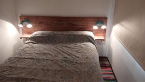 a bedroom with a bed with a wooden headboard and lights at BlackHouse in Federación