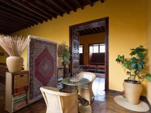 ein Wohnzimmer mit Tisch und Stühlen in der Unterkunft Live Orotava Casa antigua Patrimonio nacional in La Orotava + 21 Fotos
