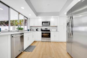 eine Küche mit weißen Schränken und Geräten aus Edelstahl in der Unterkunft Casa Azul 4Bed 2Bath Home with Heated Pool & Spa 1304 in Hollywood