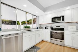 eine Küche mit weißen Schränken und einem Herd mit Backofen in der Unterkunft Casa Azul 4Bed 2Bath Home with Heated Pool & Spa 1304 in Hollywood