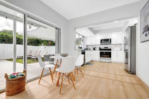 eine Küche mit weißen Schränken und einem Tisch und Stühlen in der Unterkunft Casa Azul 4Bed 2Bath Home with Heated Pool & Spa 1304 in Hollywood