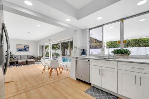 eine Küche mit weißen Schränken und ein Wohnzimmer in der Unterkunft Casa Azul 4Bed 2Bath Home with Heated Pool & Spa 1304 in Hollywood + 33 Fotos
