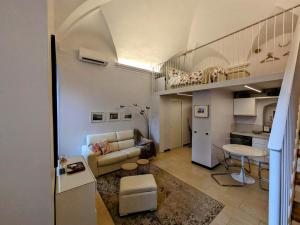 pequeña sala de estar con sofá y cocina en kaDevi piazza Bresca - pieno centro, parcheggio, bici, en San Remo