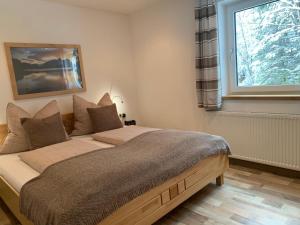 a bedroom with a large bed with a window at Haus Füsslmühle in Fuschl am See