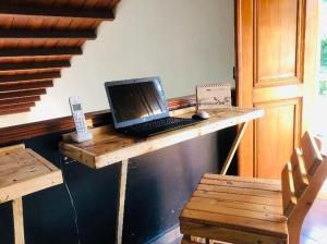 un ordenador portátil sentado en un escritorio de madera con una silla en Habitacion en La Vie en Rose en Cartagena de Indias