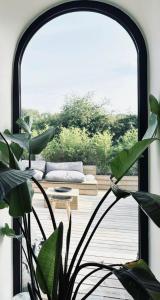 Villa Ô Wood & Chic في كوسيك: غرفة معيشة بها أريكة وبعض النباتات