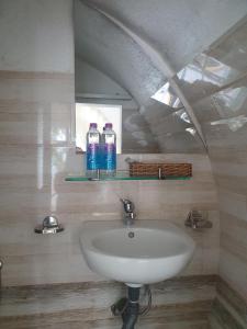 a bathroom with a sink and two bottles of water at Da Lat LUCINA Boutique Hotel in Da Lat