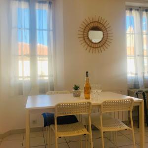een eettafel met stoelen en een fles wijn bij Studio climatisé 4 couchages centre Bandol et Plage in Bandol