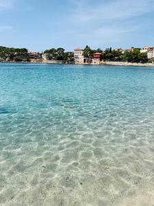 a large body of blue water with buildings in the background at Studio climatisé hypercentre Bandol et Plages in Bandol