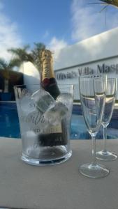 una bottiglia di champagne in un bicchiere accanto a due bicchieri di Villa Olivia Maspalomas with private pool a Maspalomas