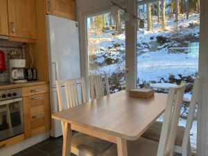 uma mesa e cadeiras numa cozinha com uma janela em House with green garden, Göteborg, 6 beds em Lindome