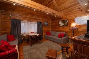 a living room with a couch and a table at Poleskie zacisze, domek Bocian, kominek, balia,sauna,wifi in Helenin