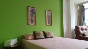 a bedroom with green walls and a bed with two pillows at Apartamento na Praia de Copacabana in Rio de Janeiro