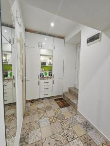 uma cozinha com armários brancos e piso em azulejo em Smart studio in the heart of Budapest em Budapeste
