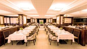 uma sala de jantar com mesas e toalhas de mesa brancas em Kubitschek Plaza Hotel - Flat Particular 2 em Brasília