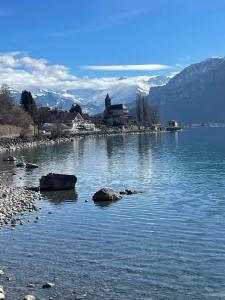 um grande corpo de água com uma igreja no fundo em Ferienwohnung Sonnenseite Brienz em Brienz