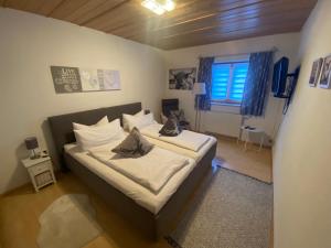 - une chambre avec un lit doté de draps blancs et une fenêtre dans l'établissement Haus Holly, à Ruhpolding