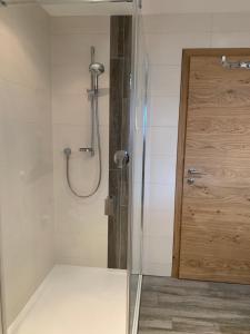 a shower with a glass door in a bathroom at Haus Füsslmühle in Fuschl am See