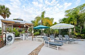 een groep stoelen en parasols op een patio bij Skipper's Landing - 4 Bedroom with Heated Pool in Cocoa Beach