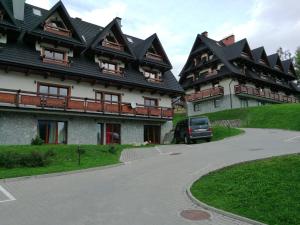 a building with a car parked in front of it at APARTAMENT "NA MOCARNI" in Kościelisko