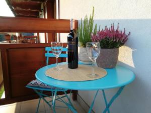 a blue table with a bottle of wine and two glasses at APARTAMENT "NA MOCARNI" in Kościelisko