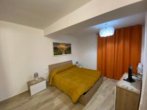 a bedroom with a bed with a yellow blanket at Home Sweet Home in Foligno