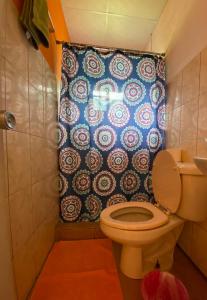 a bathroom with a toilet and a shower curtain at Rainforest Yasmin Hotel in Santa Fé